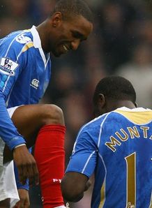Sulley Muntari wipes the boots of goalscorer Jermain Defoe