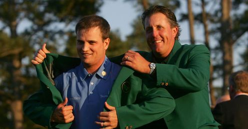 Green with envy: Johnson is handed his green jacket by Phil Mickelson