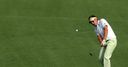 Ian Poulter chips at the first.