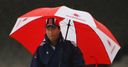 Michael Vaughan takes shelter under his umbrella as rain delays the start of the Test summer.