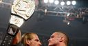 WWE Champion Triple H holds his title up high after his face-off with Randy Orton.
