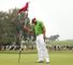 Paul Casey retrieves his ball after a birdie.