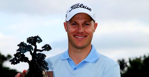 Ben Crane holds up the new Farmers Insurance trophy
