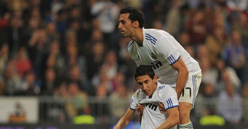 Helping hand: Álvaro Arbeloa helps a flagging Di Maria to his feet in Real's win over Racing