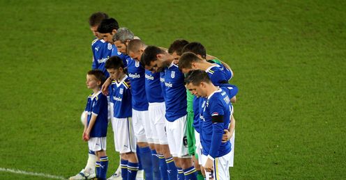 Mark of respect: the players observe a minute's silence at Cardiff in midweek