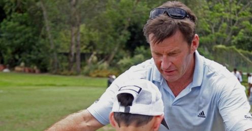 Nick Faldo giving some golfing tips to a Faldo Series partcipant