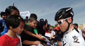 Mark Cavendish signs autographs before the start of stage three...