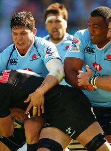 Waratahs centre Tom Carter tackling Sharks flank Marcell Coetzee