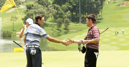 Charl Schwartzel (L) and Louis Oosthuizen shake hands on the 18th.