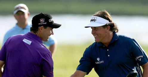 Padraig Harrington (L) and Phil Mickelson shake hands as the prepare to start their second rounds.