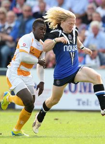 Tom Biggs of Bath kicks the ball upfield to beat Christian Wade