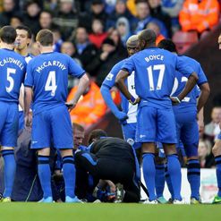 Wigan's players surround the injured Ben Watson