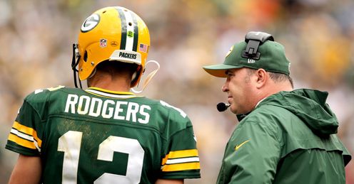 Aaron Rodgers of the Green Bay Packers confers with head coach Mike McCarthy