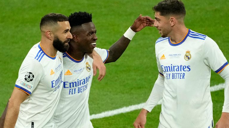 Real Madrid's Vinicius Junior, center, celebrates with Real Madrid's Karim Benzema, left, and Real Madrid's Federico Valverde after scoring his side's opening goal during the Champions League final soccer match between Liverpool and Real Madrid at the Stade de France in Saint Denis near Paris, Saturday, May 28, 2022. (AP Photo/Christophe Ena)