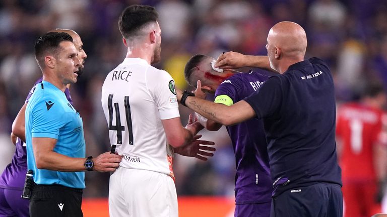 Fiorentina's Cristiano Biraghi receives treatment after objects are thrown from the West Ham supporters' end