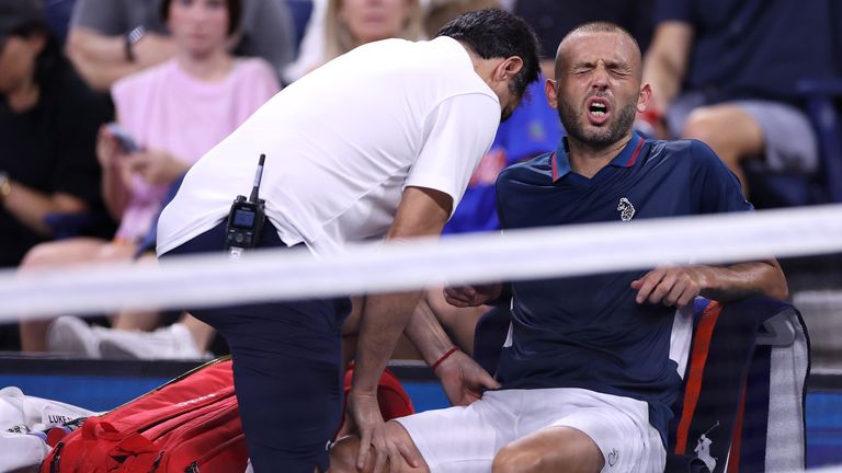 Dan Evans of Great Britain reacts as he is treated by a trainer between games against Alex de Minaur of Australia during their Men&#39;s Singles Third Round match on Day Six of the 2024 US Open at USTA Billie Jean King National Tennis Center on August 31, 2024 in the Flushing neighborhood of the Queens borough of New York City. (Photo by Luke Hales/Getty Images)