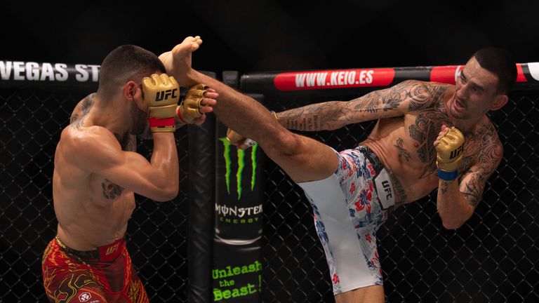 Max Holloway (right) kicks at champion Ilia Topuria during his defeat in Abu Dhabi