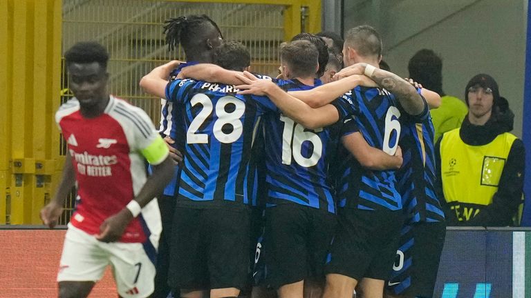 Inter's Hakan Calhanoglu is surrounded by his team-mates after scoring his side's opener against Arsenal