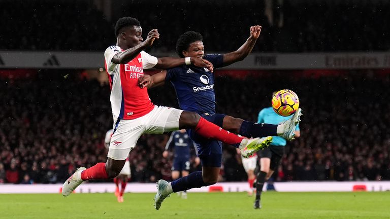 Arsenal's Bukayo Saka and Manchester United's Tyrell Malacia (right) battle for the ball