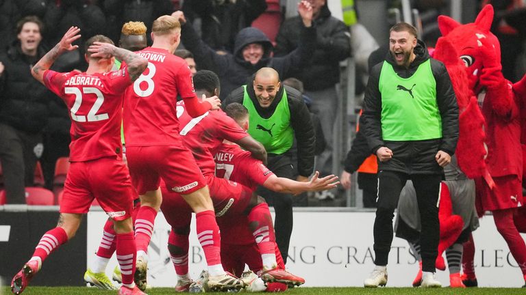 Jamie Donley is mobbed by his team-mates after his long-range effort leads to a own goal from Stefan Ortega to give Leyton Orient a shock lead against Manchester City