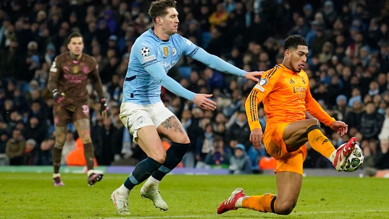 Real Madrid's Jude Bellingham, right, scores his sides third goal during the Champions League playoff first leg soccer match between Manchester City and Real Madrid at the Etihad Stadium in Manchester, England, Tuesday, Feb. 11, 2025. (AP Photo/Dave Thompson)