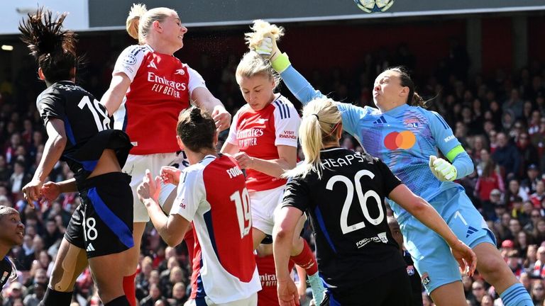 Lyon goalkeeper Christiane Endler concedes a penalty as her attempted punch strikes Leah Williamson