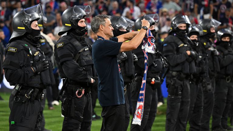 Luis Enrique celebrates with PSG fans amid riot police