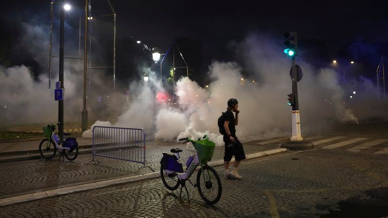 A man walks past tear gas during incidents after the Champions League final