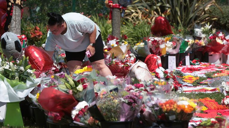A fan adds their tribute among many others outside Anfield