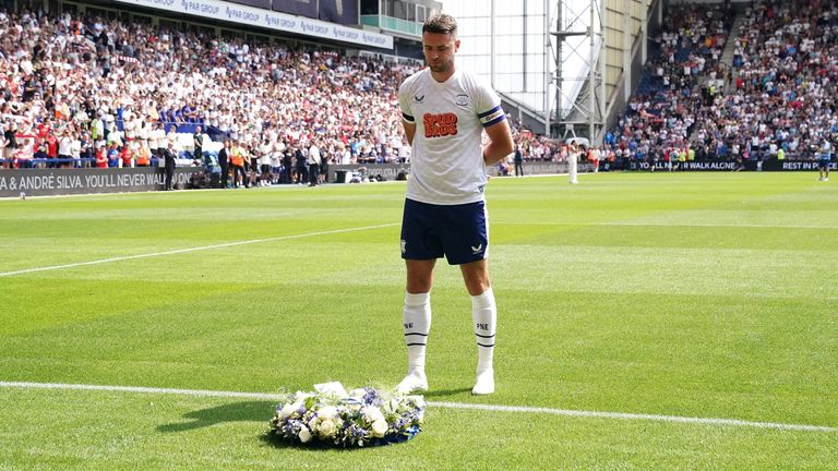 Preston captain Ben Whiteman lays a wreath in front of the Liverpool fans in honour of Diogo Jota
