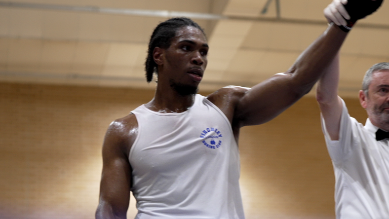Ibekwe has his hand raised in victory.