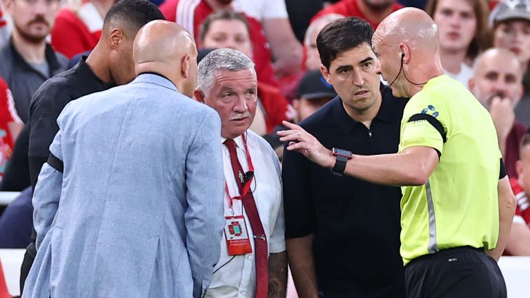Referee Anthony Taylor speaks to Bournemouth boss Andoni Iraola (left) and Arne Slot (right) after Antoine Semenyo reported racist abuse