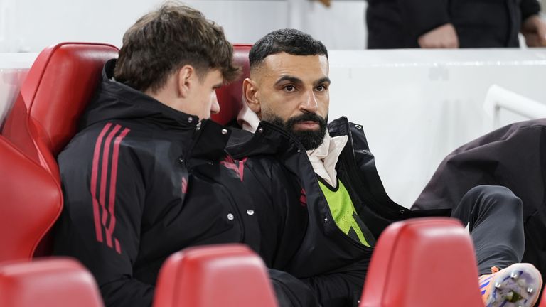 Mohamed Salah speaks with Milos Kerkez on the Liverpool bench before kick off