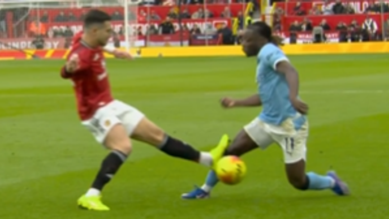 Diogo Dalot only received a yellow card for this challenge on Jeremy Doku