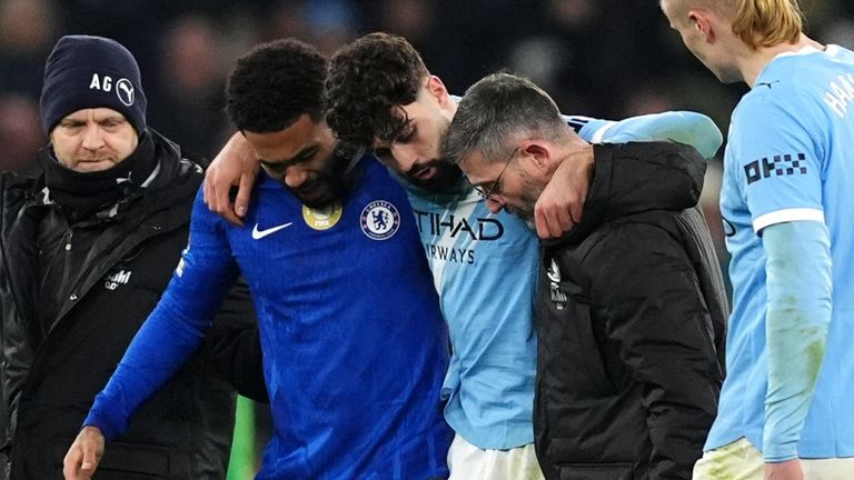 Manchester City's Josko Gvardiol leaves the pitch with help from Chelsea's Reece James after picking up an injury