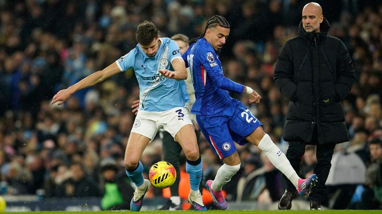 Manchester City's Ruben Dias and Chelsea's Malo Gusto vie for possession with Pep Guardiola looking on (AP Photo/Dave Thompson)