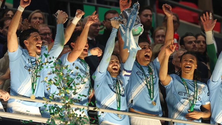 Bernardo Silva lifts the Carabao Cup as his Man City team-mates celebrate