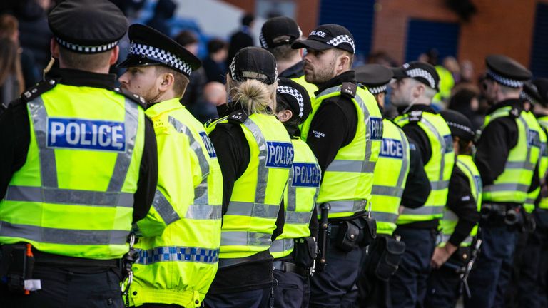 Police line up to block fans from storming the pitch at full time at Ibrox