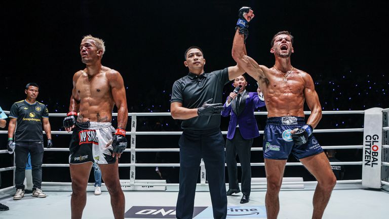 Jarvis has his hand raised in victory.