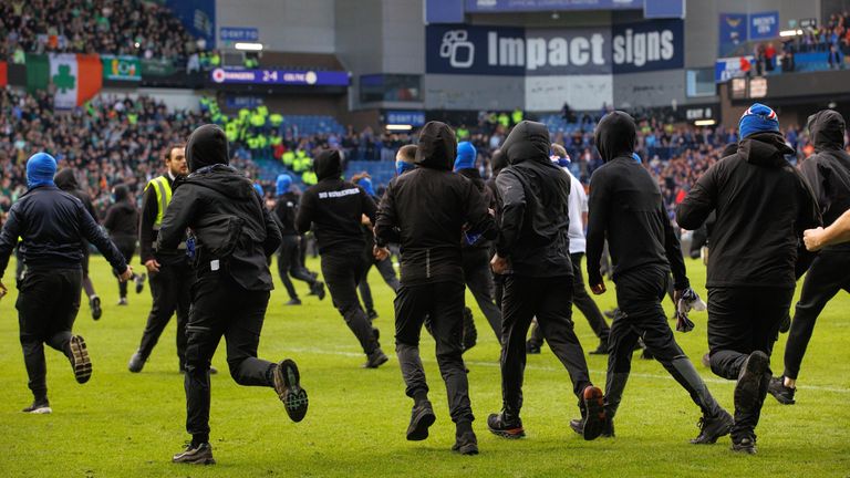 Spectators run onto the pitch at Ibrox