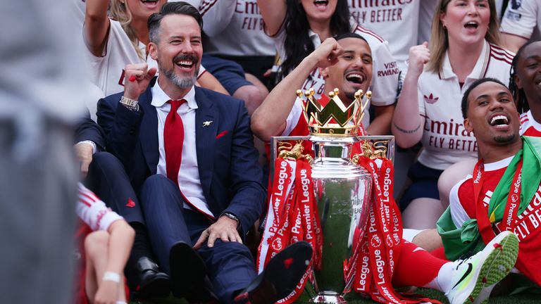Josh Kroenke celebrates with the Premier League trophy alongside William Saliba
