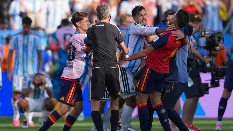 Argentina's Leandro Paredes (5) grabs Spain's Eric Garcia (4) by the neck as assistant referee Tomaz Klancnik, of Slovenia, tries to break up a scuffle after the World Cup final soccer match between Spain and Argentina in East Rutherford, N.J., near New York, Sunday, July 19, 2026. (AP Photo/Julio Cortez)