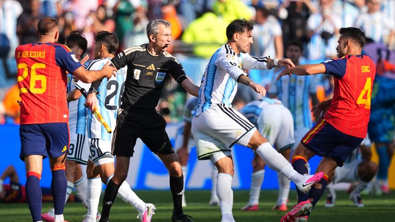 Argentina's Leandro Paredes (5) kicks at Spain's Eric Garcia (4) as assistant referee Tomaz Klancnik, of Slovenia, tries to break up a scuffle after the World Cup final soccer match between Spain and Argentina in East Rutherford, N.J., near New York, Sunday, July 19, 2026. (AP Photo/Julio Cortez)